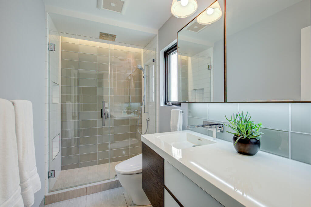 A light and airy bathroom remodel showing off stone tilling and a standing shower. 